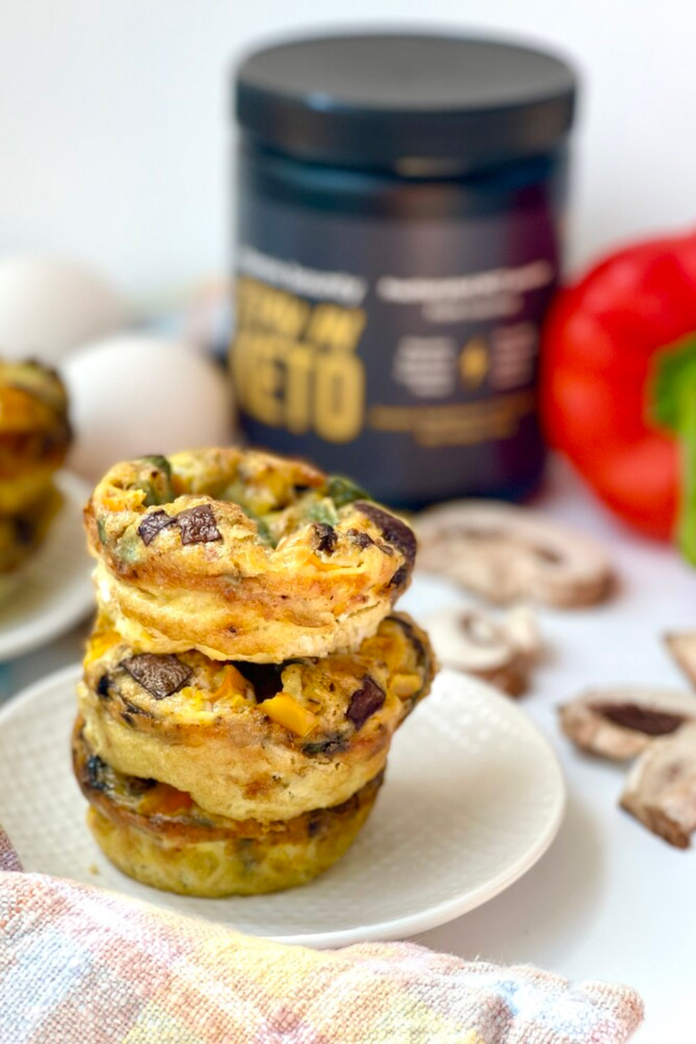 Egg Bites made with Stay in Keto. Pictured on a white ceramic plate, stacked on top of one another