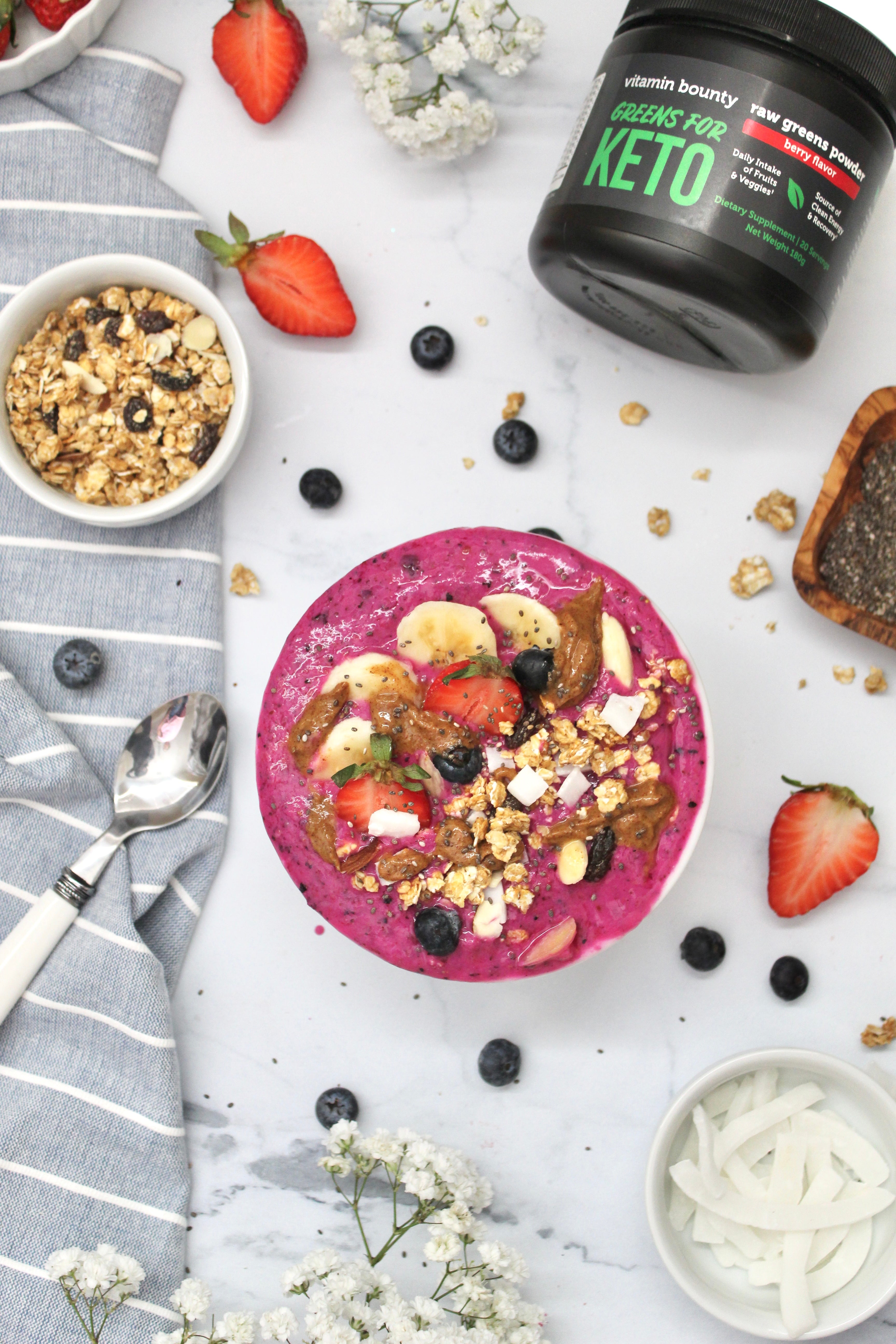 Bright purple smoothie bowl made with greens for keto and topped with seeds and berries