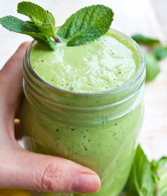 Green smoothie in a mason jar topped with mint