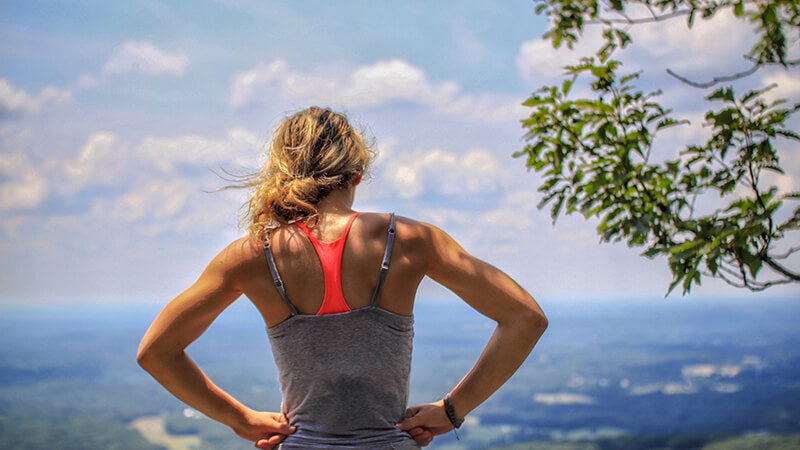 woman at the top of a mountain, looking out on the ocean