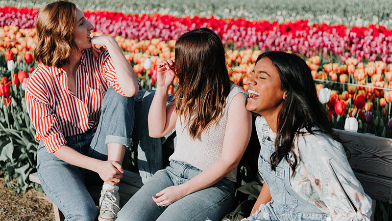 Three women in a large colorful tulip field