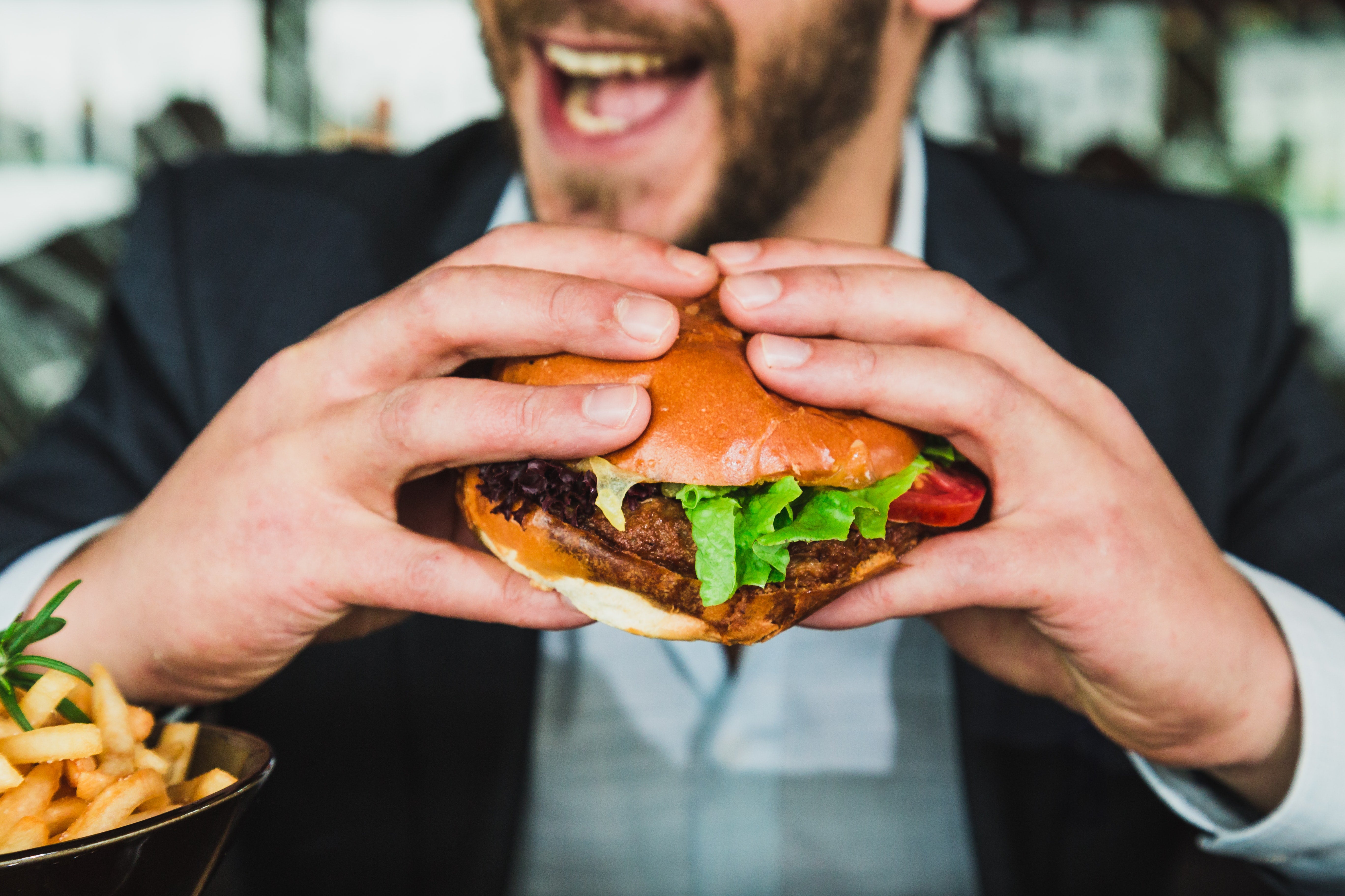 man smiling eating a keto burger