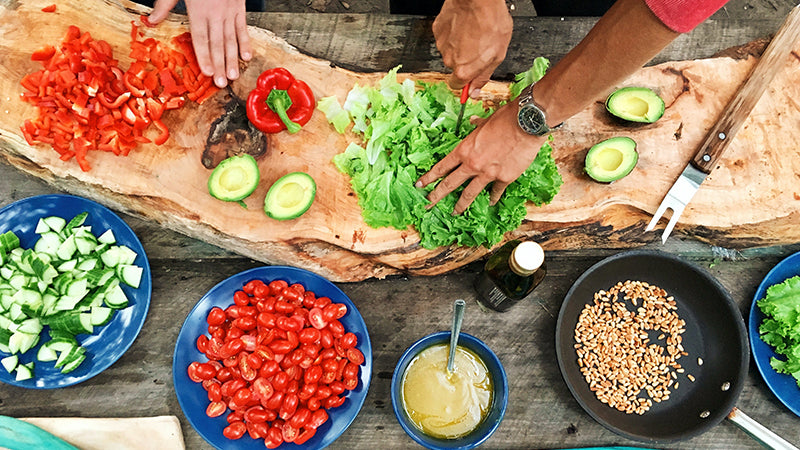 salad being made on a wood board surrounded with ingredients