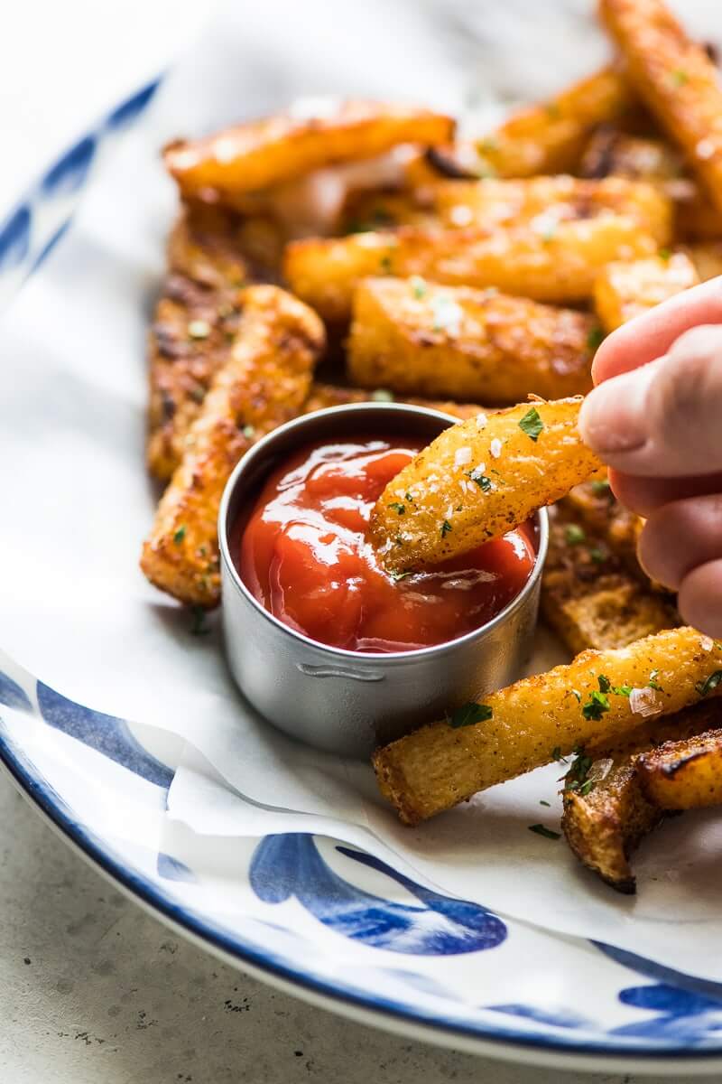Baked Jicama Fries on a blue and white bowl with ketchup on the side