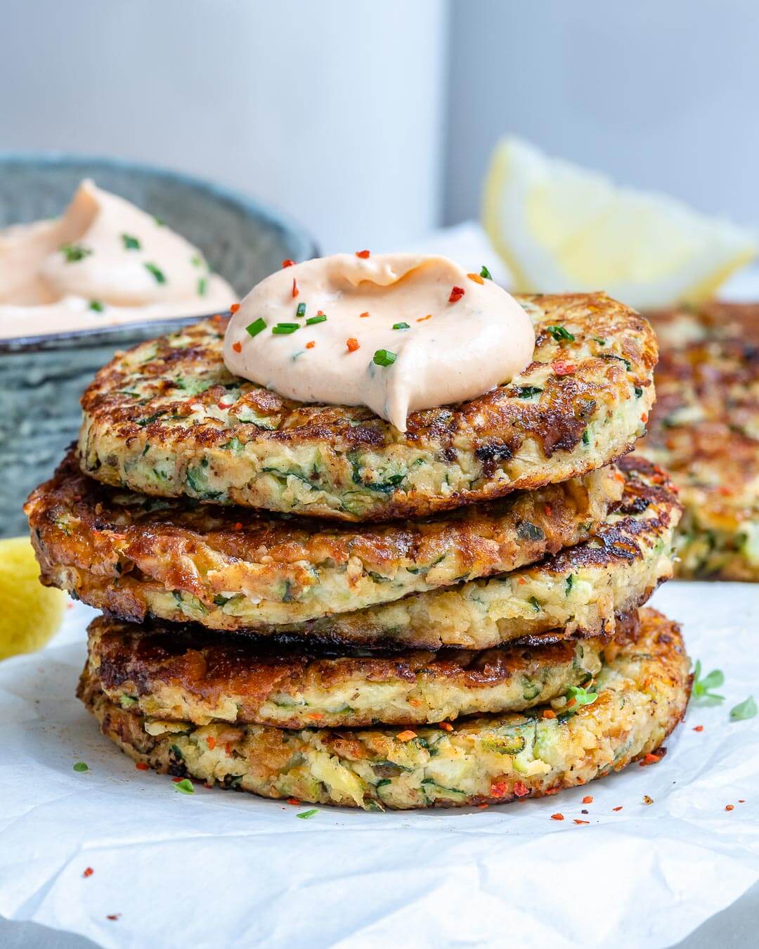 Cheesy Zucchini Fritters piled up With Spicy Ranch Dip