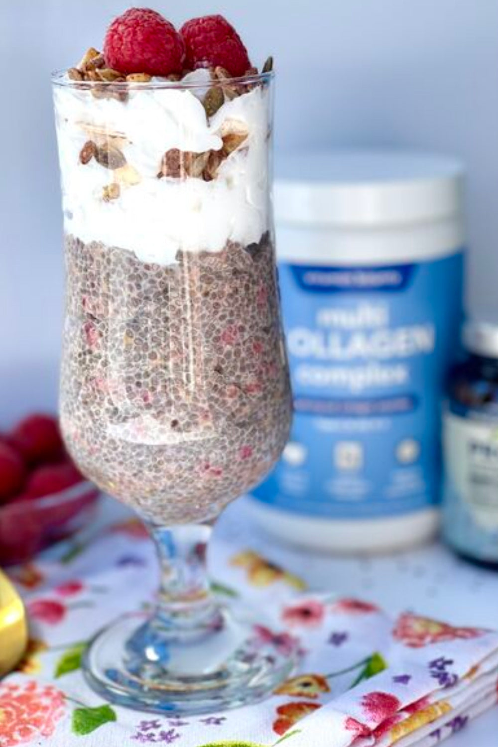 Multi Collagen Complex Chia Seed Pudding Parfait pictured in a tall glass with whipped cream and raspberries on top