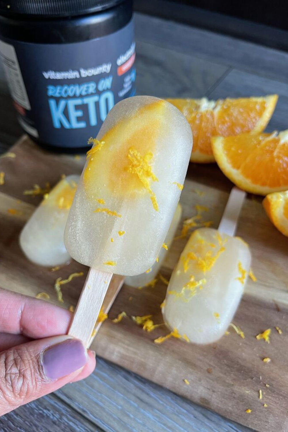 Recover on Keto Electrolyte Popsicles pictured with orange slices 