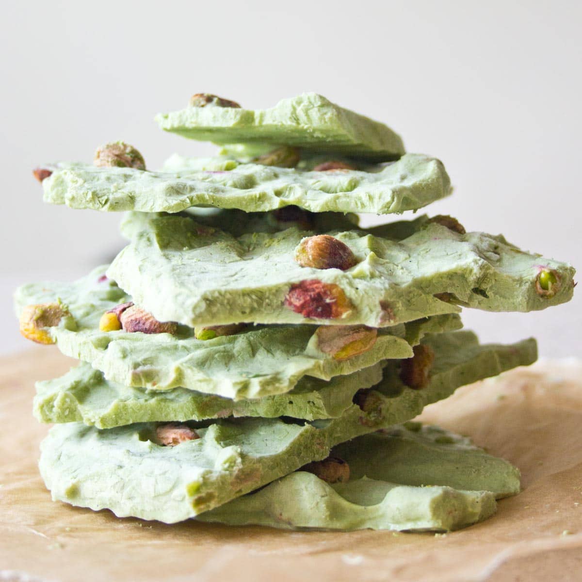 Matcha Frozen Yogurt Bark stacked on top of each other. About 10 pieces.
