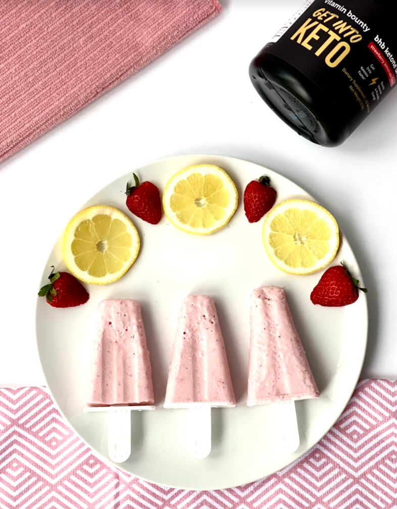 Strawberry lemonade popsicles on a white plate made with Stay in Keto by Vitamin Bounty
