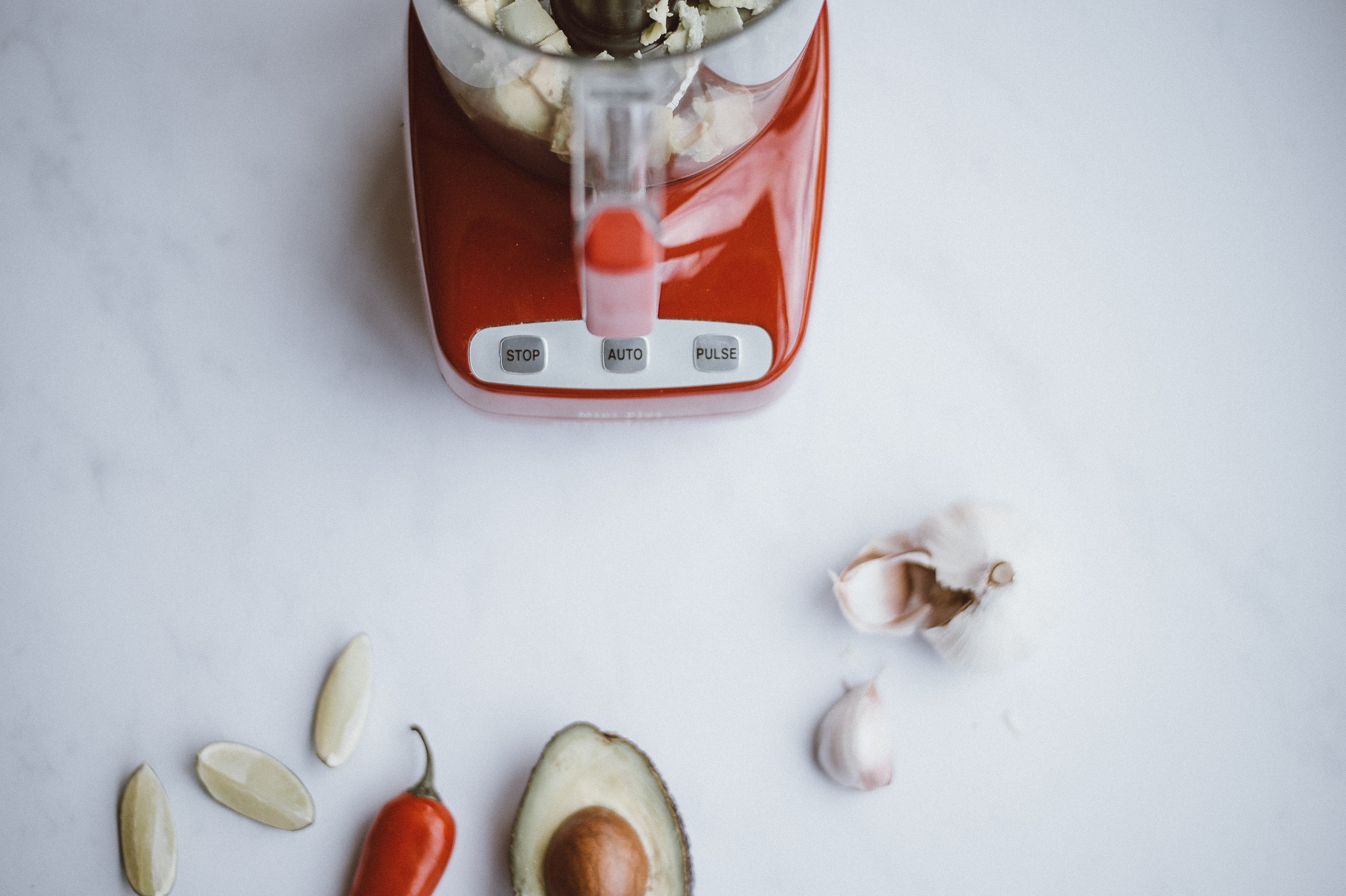 Photo of red blender with vegetables surrounding it