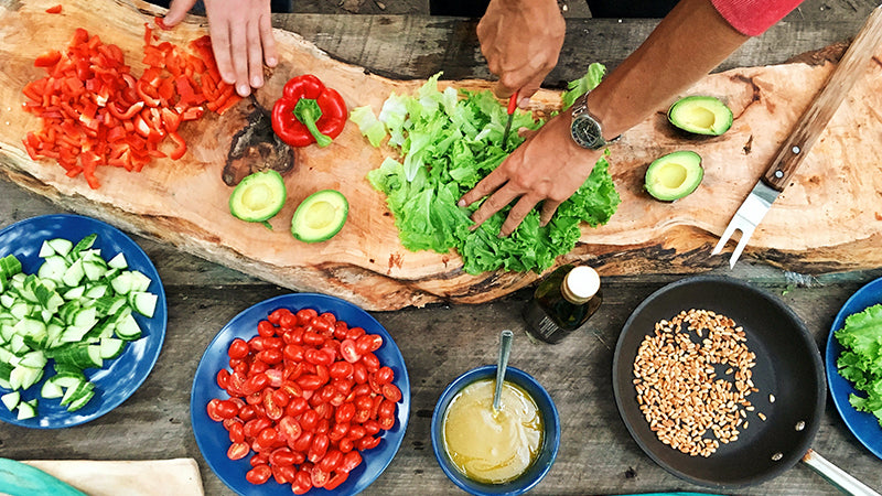 salad being made on a wood board surrounded with ingredients 